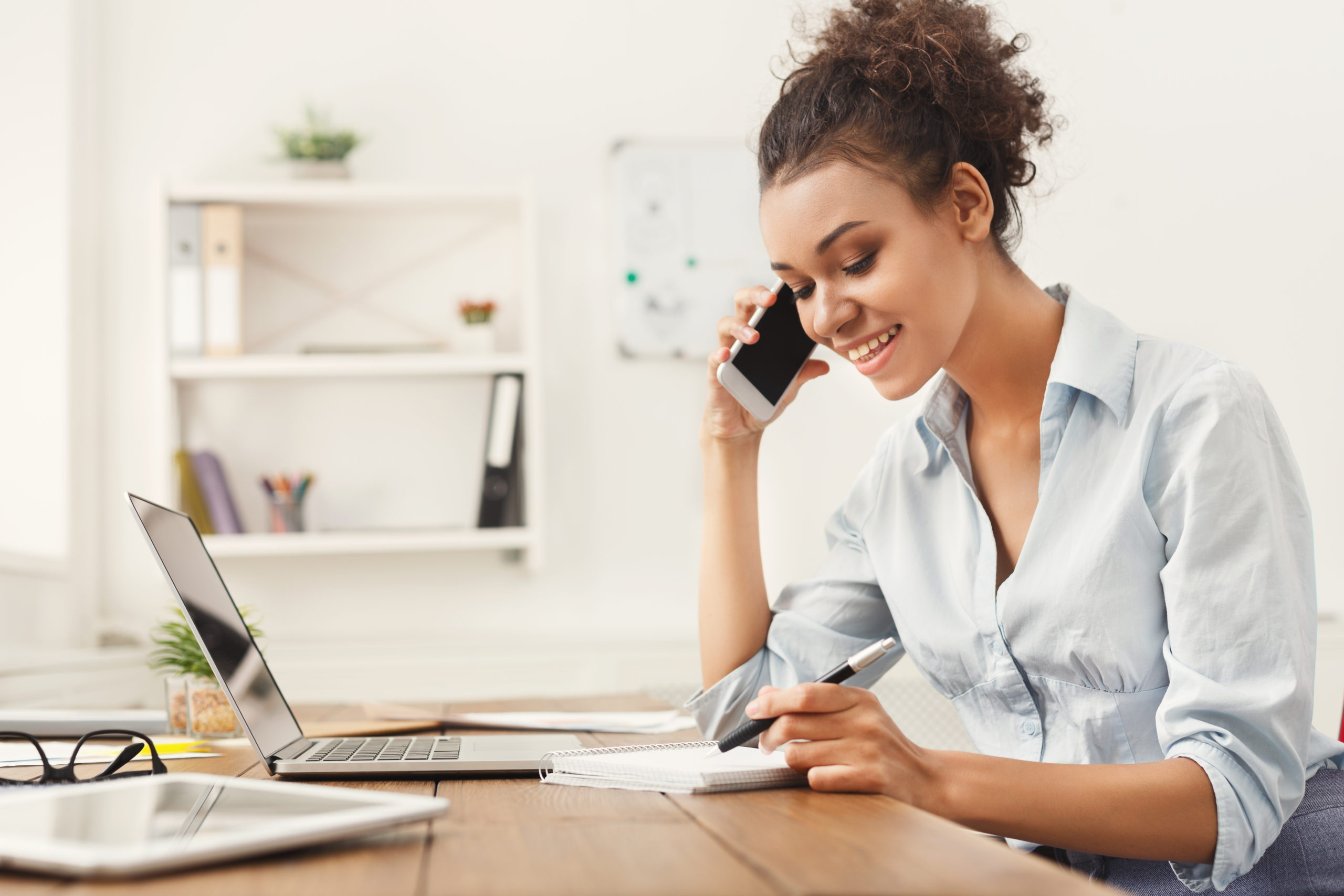 Smiling business woman at work talking on phone